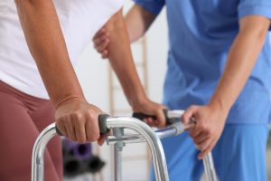 A physical therapist helping a patient with walking exercises as part of joint replacement surgery recovery.